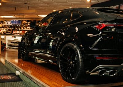 a shot of a black car inside of a showroom